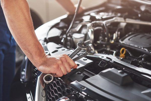 Picture showing muscular car service worker repairing vehicle Picture showing muscular car service worker repairing vehicle.